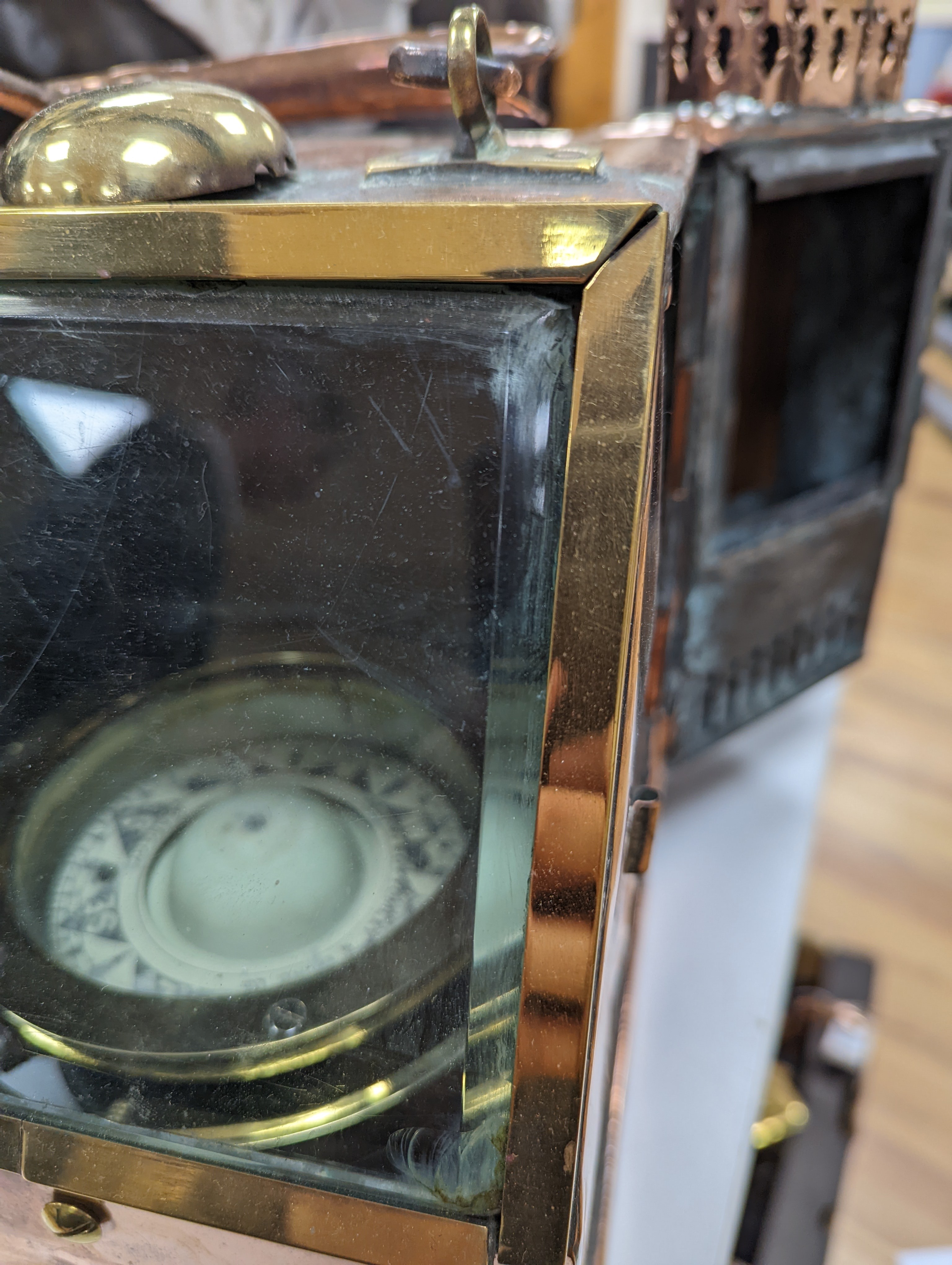 A copper ship's binnacle compass, a brass oil lamp, a brass jug and a copper kettle